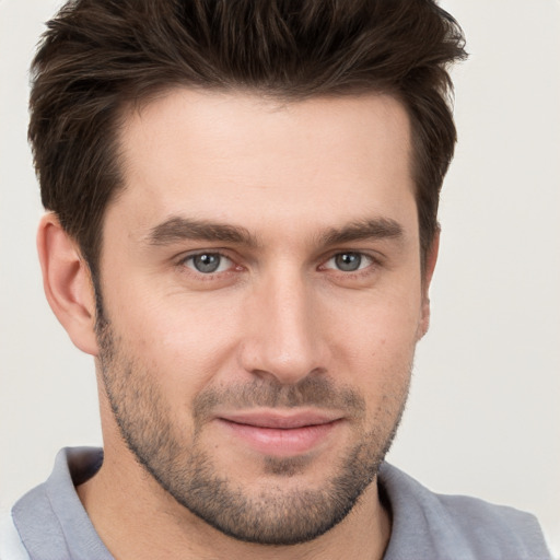 Joyful white young-adult male with short  brown hair and grey eyes