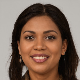 Joyful latino young-adult female with long  brown hair and brown eyes