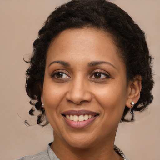 Joyful black adult female with medium  brown hair and brown eyes