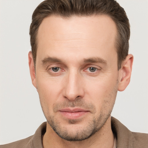 Joyful white young-adult male with short  brown hair and grey eyes