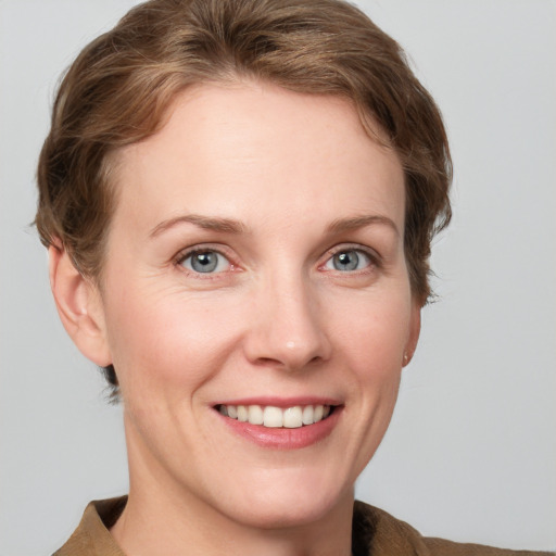 Joyful white adult female with medium  brown hair and grey eyes