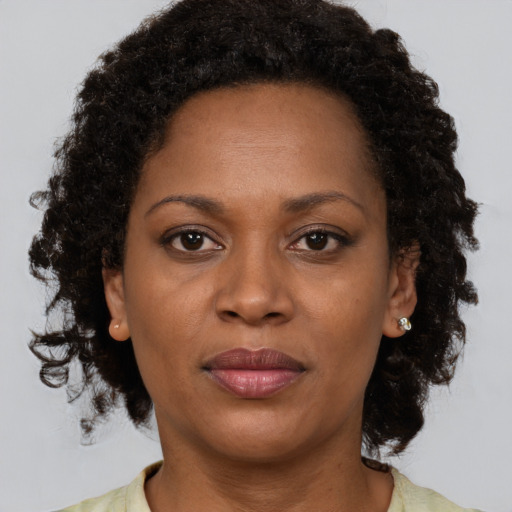 Joyful black adult female with medium  brown hair and brown eyes