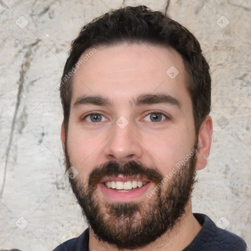 Joyful white young-adult male with short  black hair and brown eyes