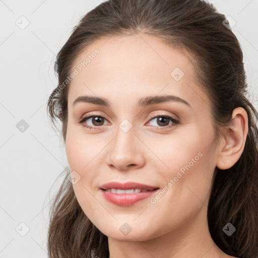 Joyful white young-adult female with long  brown hair and brown eyes