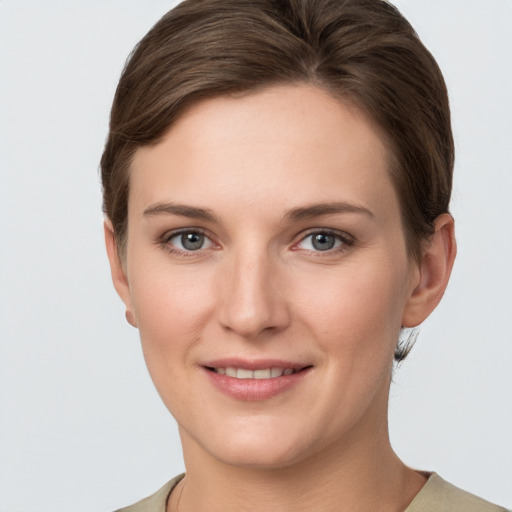 Joyful white young-adult female with short  brown hair and grey eyes