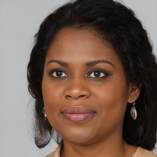 Joyful black young-adult female with long  brown hair and brown eyes