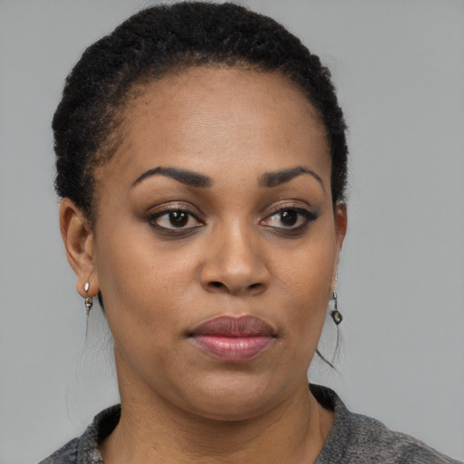 Joyful black young-adult female with short  black hair and brown eyes