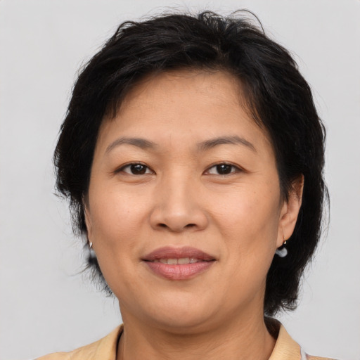 Joyful latino adult female with medium  brown hair and brown eyes