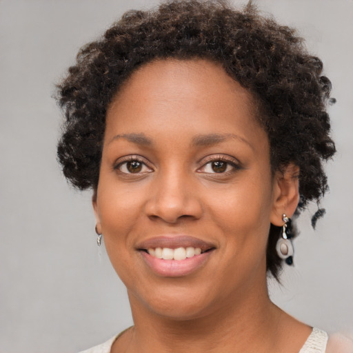 Joyful black young-adult female with short  brown hair and brown eyes