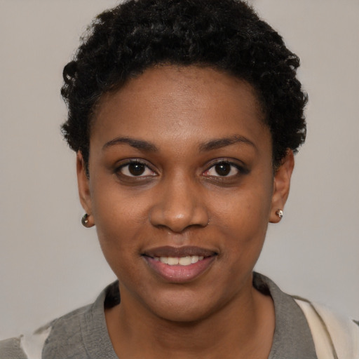 Joyful black young-adult female with short  black hair and brown eyes