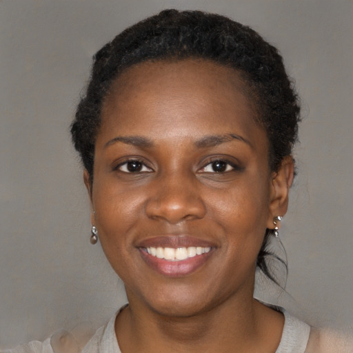 Joyful black young-adult female with short  black hair and brown eyes
