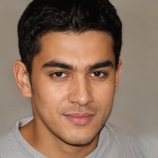 Joyful latino young-adult male with short  brown hair and brown eyes