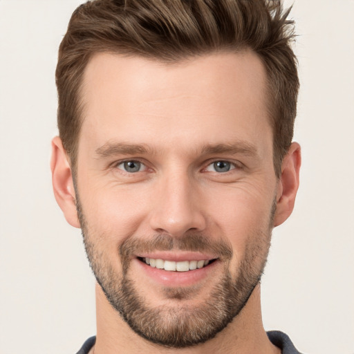 Joyful white young-adult male with short  brown hair and grey eyes