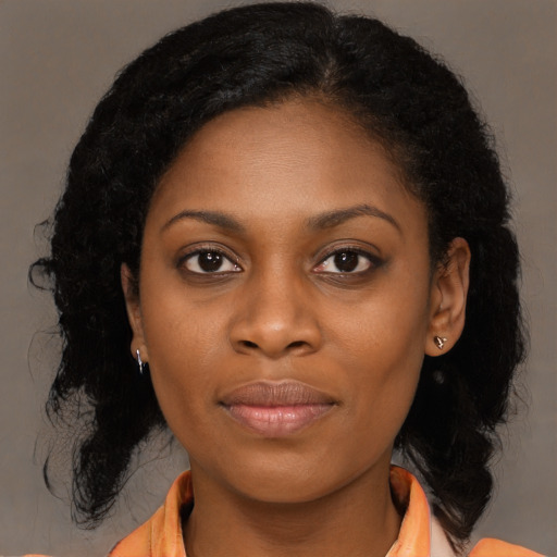 Joyful black young-adult female with long  black hair and brown eyes