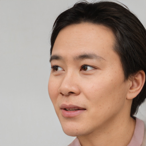 Joyful asian young-adult male with short  brown hair and brown eyes