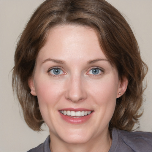 Joyful white young-adult female with medium  brown hair and blue eyes