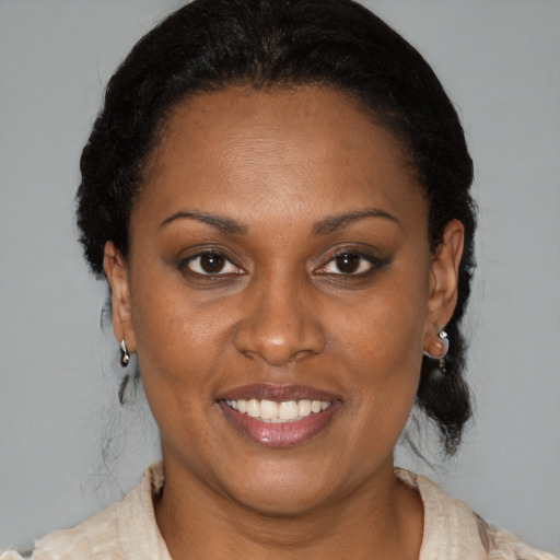 Joyful black adult female with medium  brown hair and brown eyes