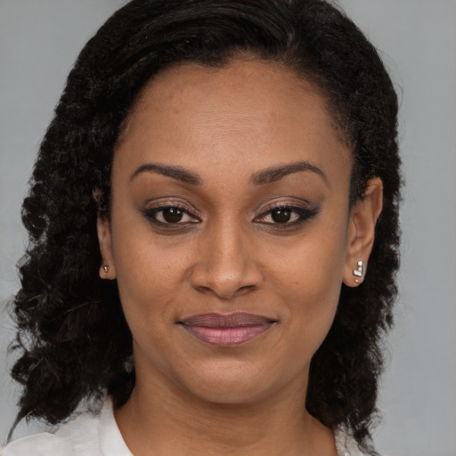 Joyful black young-adult female with medium  brown hair and brown eyes