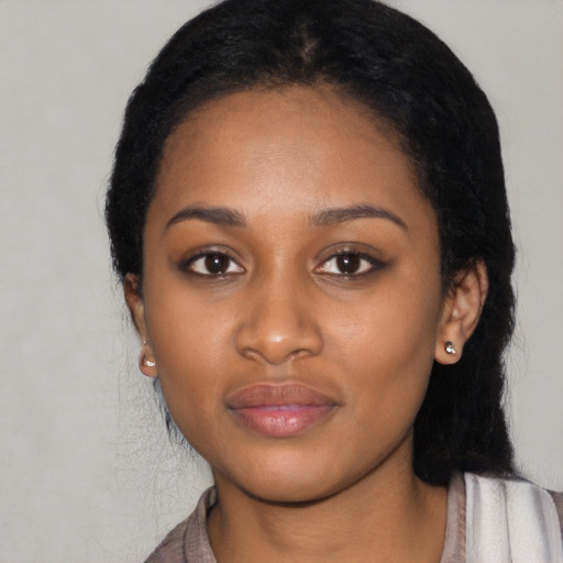 Joyful black young-adult female with long  black hair and brown eyes