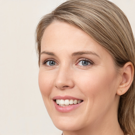 Joyful white young-adult female with long  brown hair and blue eyes