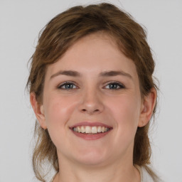 Joyful white young-adult female with medium  brown hair and grey eyes