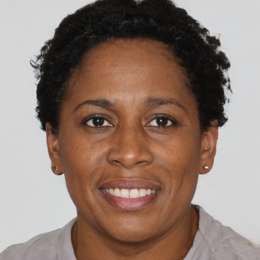 Joyful black adult female with short  brown hair and brown eyes