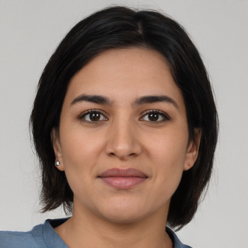 Joyful latino young-adult female with medium  brown hair and brown eyes