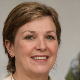 Joyful white adult female with medium  brown hair and green eyes