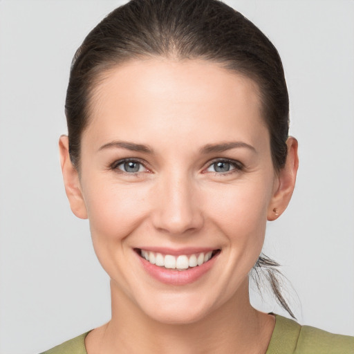 Joyful white young-adult female with medium  brown hair and grey eyes