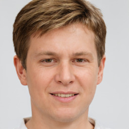 Joyful white young-adult male with short  brown hair and grey eyes