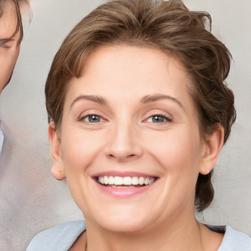 Joyful white young-adult female with medium  brown hair and grey eyes