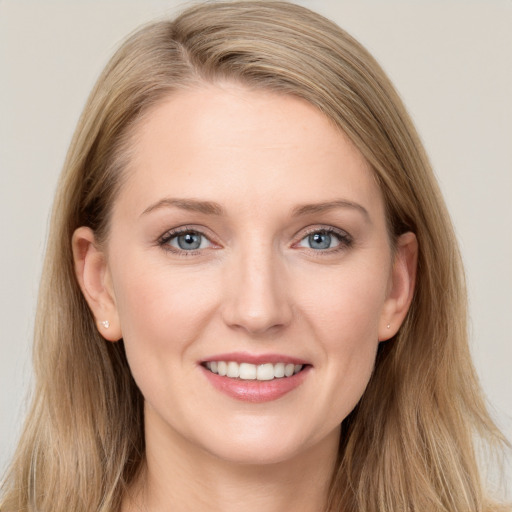 Joyful white young-adult female with long  brown hair and blue eyes