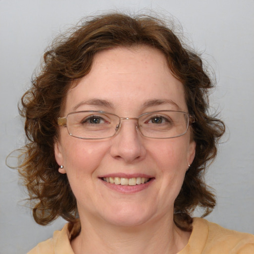 Joyful white adult female with medium  brown hair and blue eyes