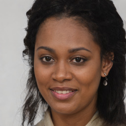 Joyful black young-adult female with long  brown hair and brown eyes