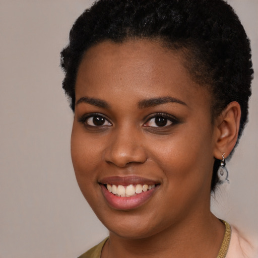Joyful black young-adult female with short  brown hair and brown eyes