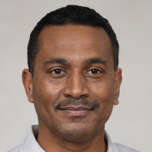 Joyful black adult male with short  black hair and brown eyes