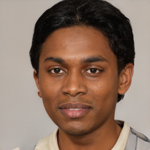 Joyful black young-adult male with short  black hair and brown eyes