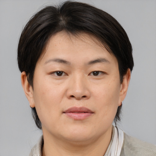 Joyful asian adult female with medium  brown hair and brown eyes
