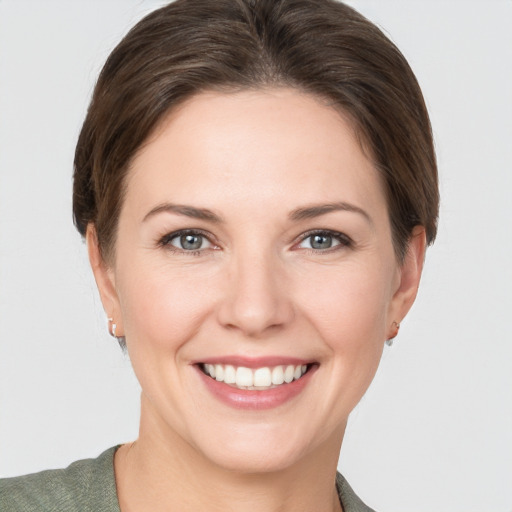 Joyful white young-adult female with short  brown hair and grey eyes