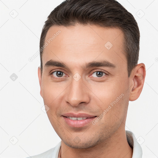 Joyful white young-adult male with short  brown hair and brown eyes