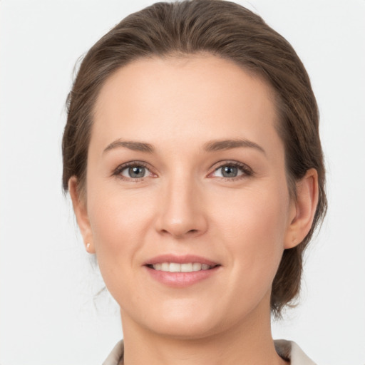 Joyful white young-adult female with medium  brown hair and grey eyes