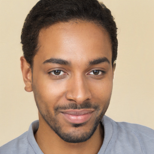 Joyful black young-adult male with short  brown hair and brown eyes