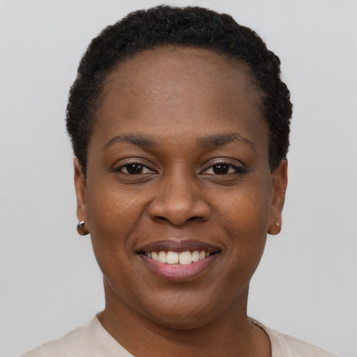 Joyful black young-adult female with short  brown hair and brown eyes