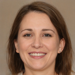 Joyful white adult female with long  brown hair and brown eyes