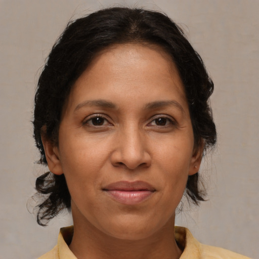 Joyful latino adult female with medium  brown hair and brown eyes