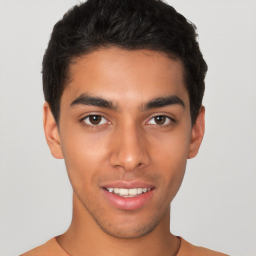 Joyful latino young-adult male with short  brown hair and brown eyes