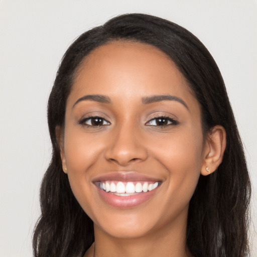 Joyful latino young-adult female with long  black hair and brown eyes