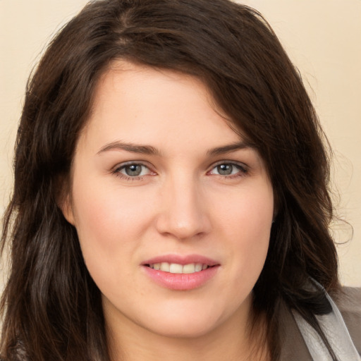 Joyful white young-adult female with long  brown hair and brown eyes