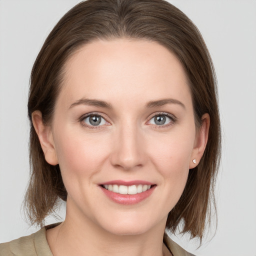 Joyful white young-adult female with medium  brown hair and grey eyes