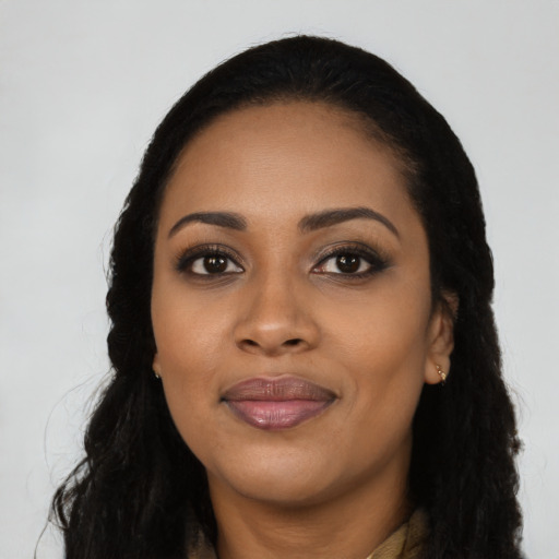 Joyful black young-adult female with long  black hair and brown eyes